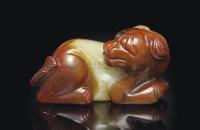 A YELLOW AND RUSSET JADE CARVING OF A DOG