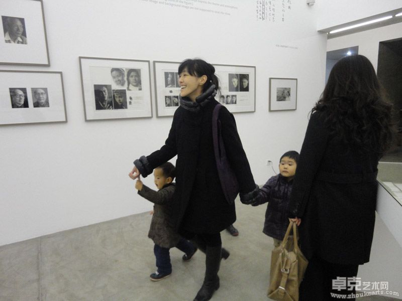 三影堂摄影艺术中心创办人之一映里女士和她的孩子在展览现场