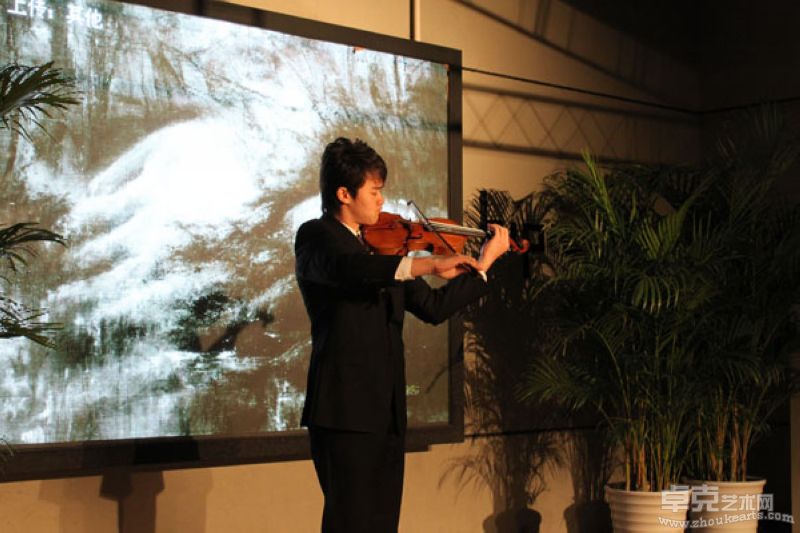 著名小提琴手在孙尧的风景画背景下激情演奏
