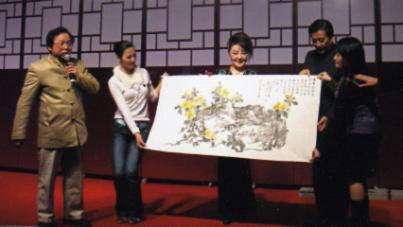 2005年张建富将忘年师友孙家勤大师的大画，请好友远东十大歌星杨燕，在盛大的两岸农经文化交流两三百人