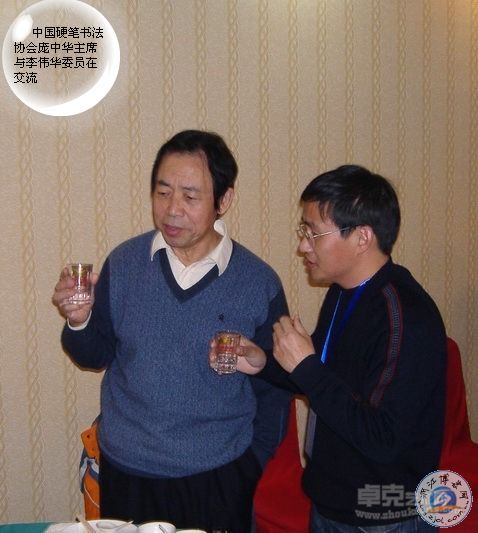 时任中国硬笔书法协会主席庞中华与李伟华委员在交流