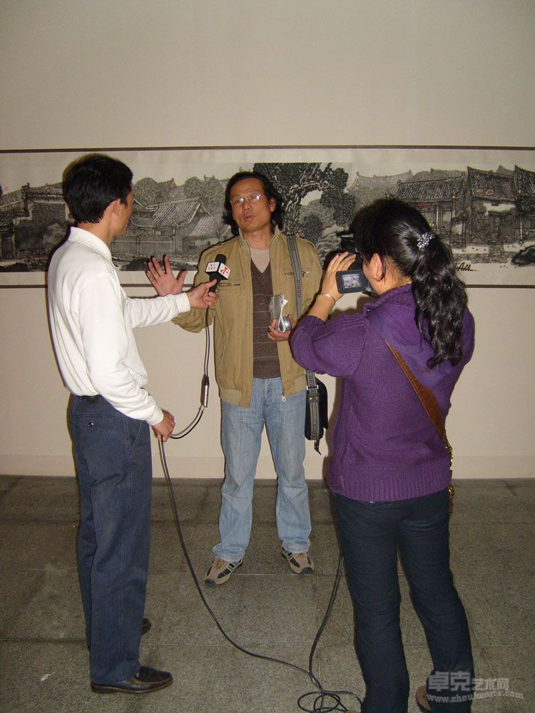 潘世龙在画展现场接受媒体采访